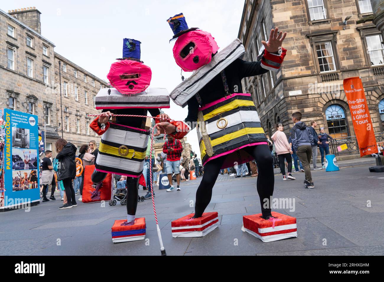 Edinburgh, Schottland, Großbritannien. August 2023. Edinburgh Royal Mile war während des Fringe Festivals sehr voll. Das gute Wetter am Wochenende brachte Tausende von Besuchern zur Royal Mile in Edinburgh, um Straßenkünstler zu sehen und die Festivalatmosphäre zu erleben. PIC; Schauspieler, die ihre Show mit Bertie von Liquorice Allsorts bewerben. Iain Masterton/Alamy Live News Stockfoto