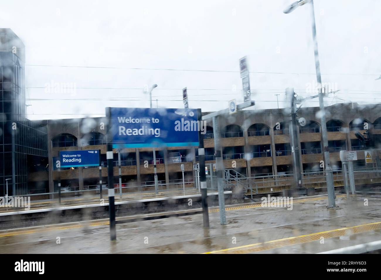 Willkommen in der Stadt der Lesung Schild durch Regen verschwommen auf einem leeren Bahnsteig British Rail nassen Sommertag 2023 England Großbritannien KATHY DEWITT Stockfoto