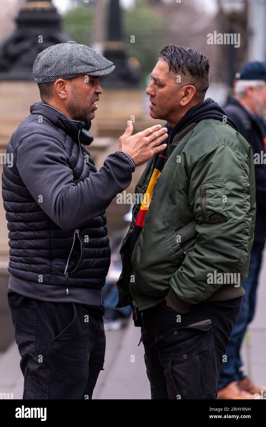 Die Demonstranten, die ein T-Shirt mit der Flagge der Aborigines tragen, unterhalten sich während einer Kundgebung mit Nein über die Schritte des Parlaments. Die australische Regierung wird ein Referendum abhalten, um die Verfassung zu ändern und eine indigene "Stimme für das parlament" aufzunehmen. Eine kleine Gruppe von rund 30 Personen versammelte sich in Melbourne bei einer der ersten öffentlichen Kundgebungen, die der Stimme gewidmet waren. Zu den Rednern zählten indigene Völker sowie Mitglieder von Randgruppen souveräner Bürgerbewegungen und andere Randgruppen, die während der COVID-19-Pandemie und der Sperrungen entstanden sind. (Foto von Michael Currie/SOPA Images/SIPA USA) Stockfoto