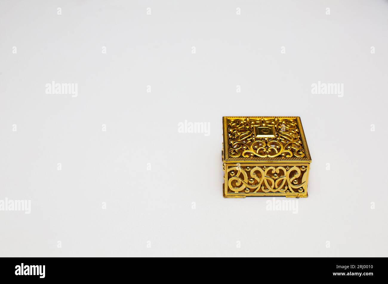 Goldene Geschenkbox auf weißem Hintergrund mit Platz für Kopien. Stockfoto