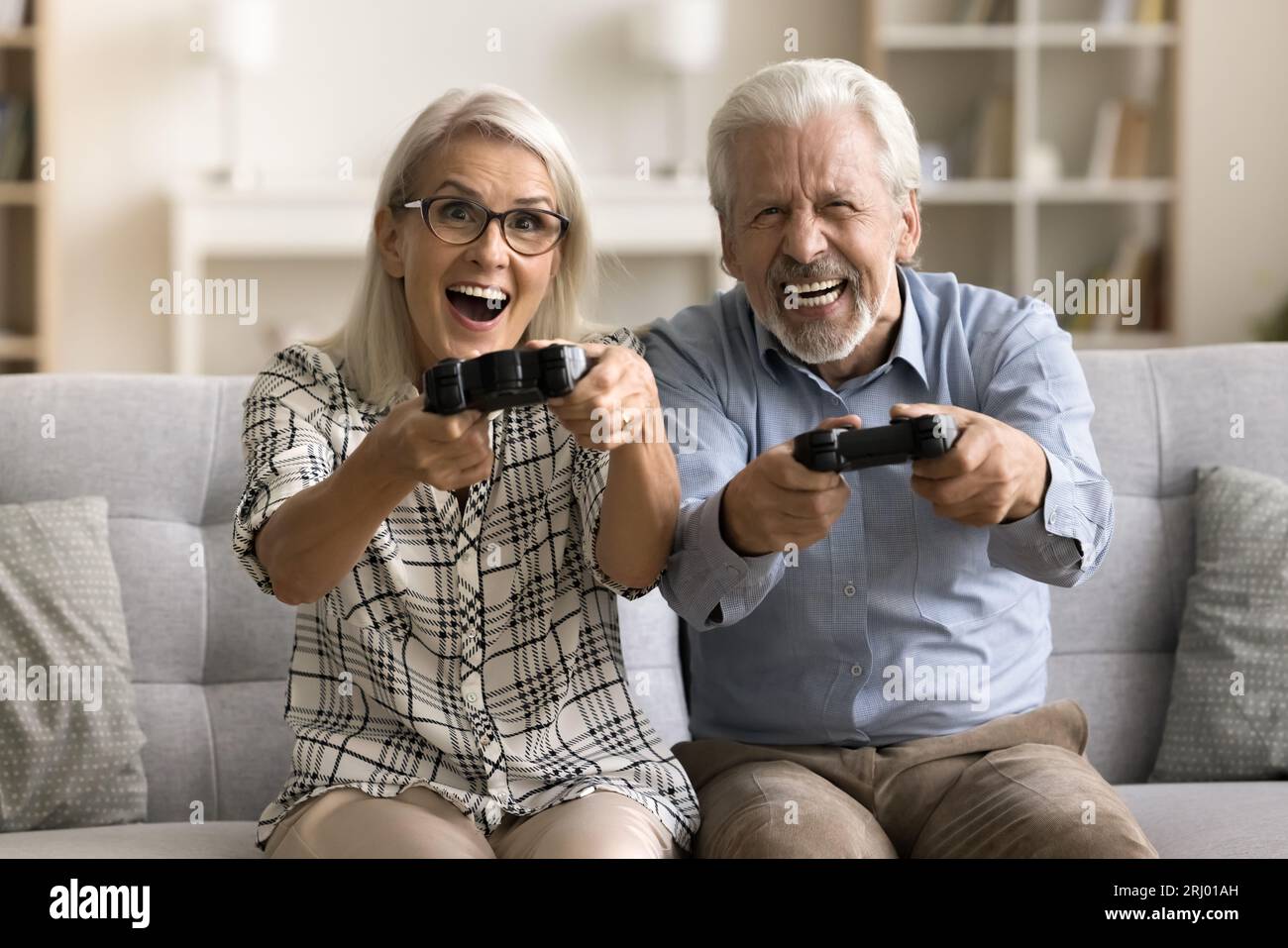 Happy Crazy pensioniertes Paar begeistert von Online-Videospiel Stockfoto