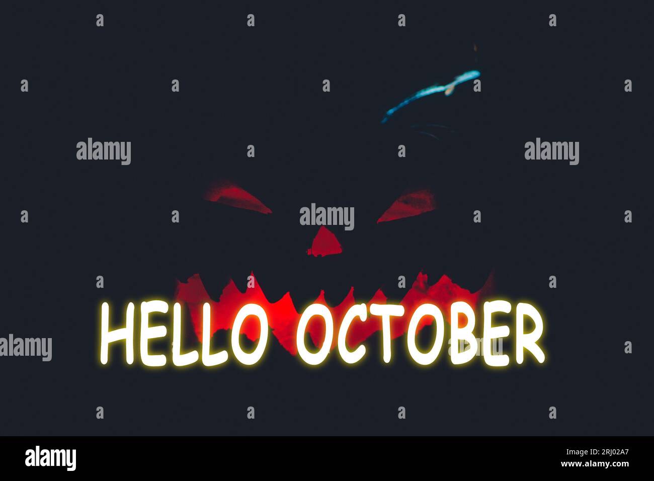 „Hallo oktober“-Schriftzug. Halloween Kürbis auf schwarzem Hintergrund. Urlaub Herbst einschüchternd Stockfoto