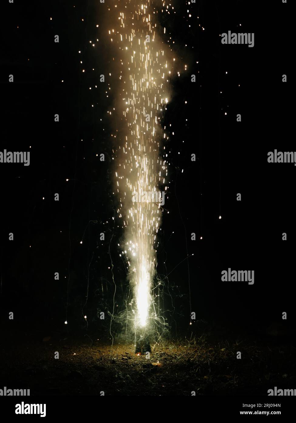 Ein Funken- und Rauchbrunnen, der nachts während eines Festivals aus einem diwali-Blumenkegel-Feuerkracher platzt Stockfoto