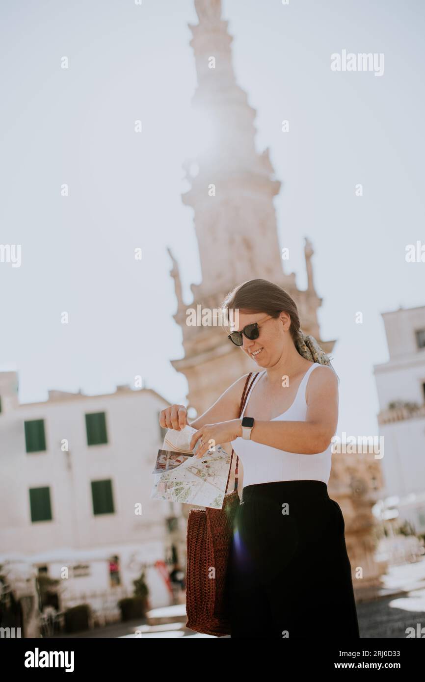 Weibliche Touristen mit einem Stadtplan von der Statue des Heiligen Oronzo in Ostuni, Italien Stockfoto