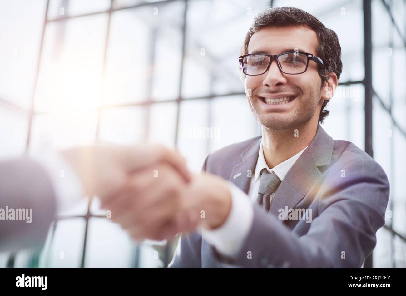 Junger Geschäftsmann, der seinem Partner die Hand schüttelt Stockfoto