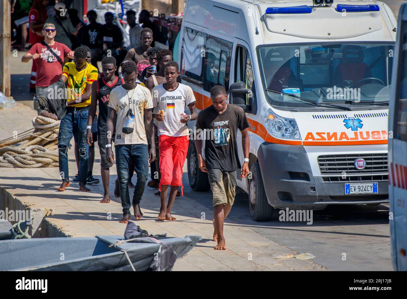 Insel Lampedusa, Rom, Italien. August 2023. Im Hafen von Lampedusa, südlich der Sahara, laufen die von der Guardia di Finanza geretteten Migranten zu den Rote-Kreuz-Bussen, die sie zum Hotspot auf der Insel Lampedusa bringen werden.Laut dem Jahresbericht des italienischen Innenministeriums, die Zahl der in Italien angelandeten Migranten hat sich im Vergleich zum Vorjahr verdoppelt. Sie kommen hauptsächlich aus Afrika südlich der Sahara, aber hauptsächlich aus Tunesien. Quelle: ZUMA Press, Inc./Alamy Live News Stockfoto