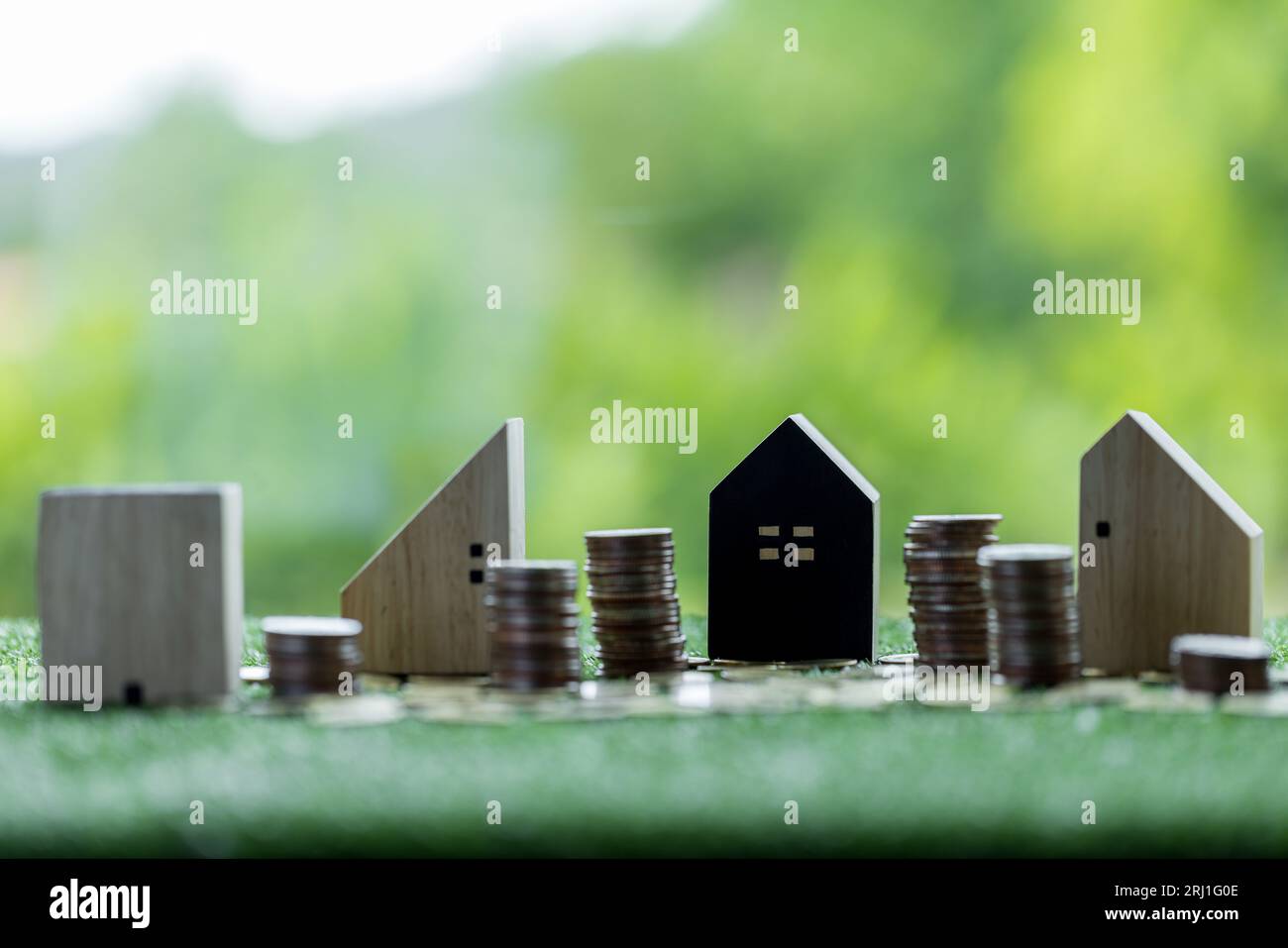 Geschäftsdarlehen für Immobilienkonzept, Geld mit Modellhaus auf dem Tisch auf Bokeh-Hintergrund im öffentlichen Park. Stockfoto