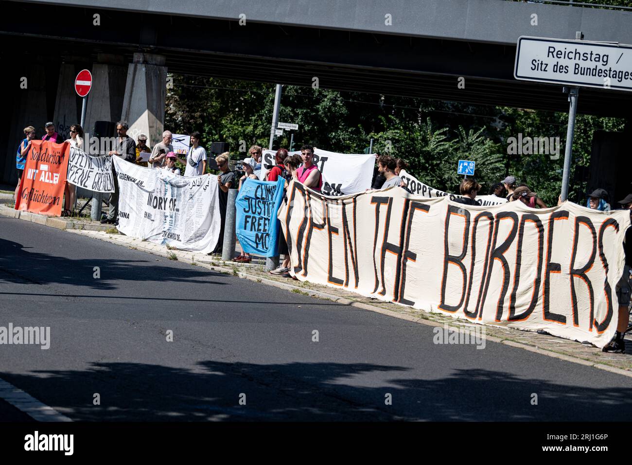 Berlin, Deutschland. August 2023. Teilnehmer der Rallye „offene Türen – offene Grenzen! Die Klimakrise als Grund für Asyl anzuerkennen!“ Die Rebellion steht vor dem Bundesministerium des Innern mit einem Banner mit der Aufschrift „Öffnen Sie die Grenzen“ am Tag der offenen Tür der Bundesregierung. Quelle: Fabian Sommer/dpa/Alamy Live News Stockfoto