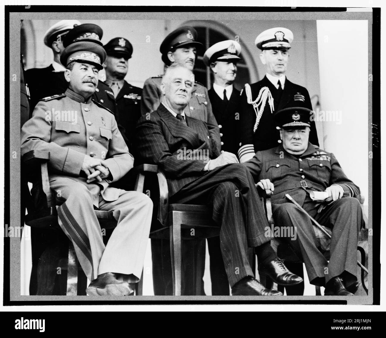 Erste Reihe: Marschall Stalin, Präsident Roosevelt, Premierminister Churchill. Zurück in der Reihe: General H. Arnold, Chief der U.S. Army Air Force; nicht identifizierter britischer Offizier; Admiral Cunningham; Admiral William Leahy, Stabschef von Präsident Roosevelt. Über den Portikus der russischen Botschaft während der Teheraner Konferenz im Dezember 1943 in Iran. Stockfoto