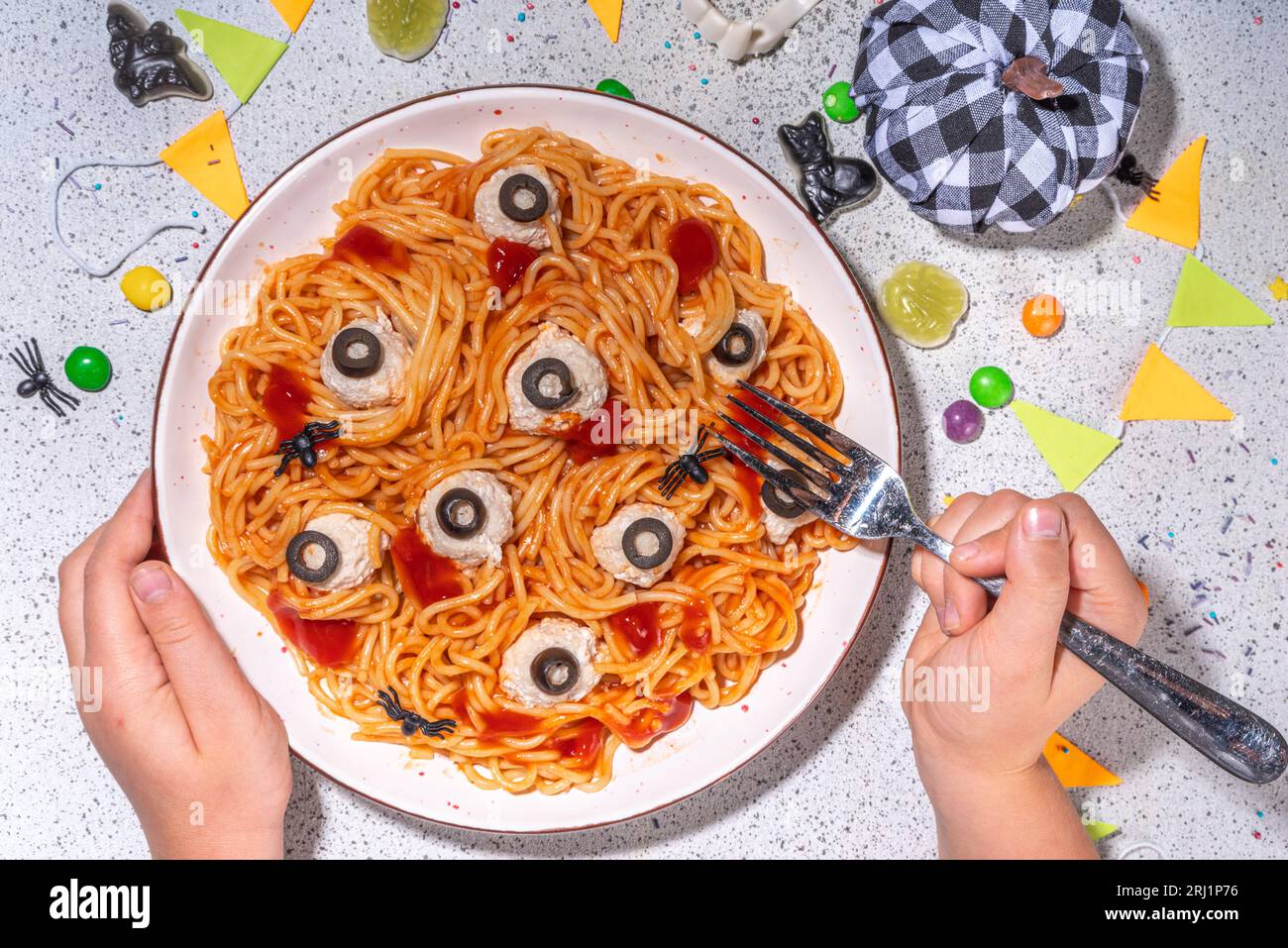 Gruselige lustige Pasta Spaghetti für Halloween Party Dinner. Spaghetti mit Tomatensauce und Hühnerfleischball, verziert mit schwarzen Oliven wie Augen, weiß Stockfoto