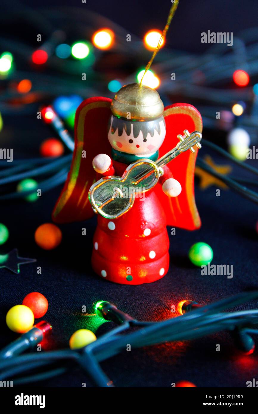 Holzengel mit Gitarre und weihnachtsbeleuchtung Stockfoto