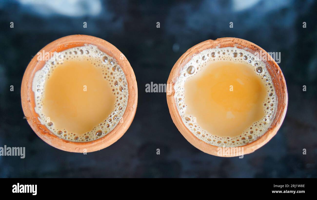 Kulhad Chai ist ein Teegetränk aus Indien, Milchtee mit aromatischen Kräutern und Gewürzen, Tasse Tee auf schwarzem Hintergrund Stockfoto