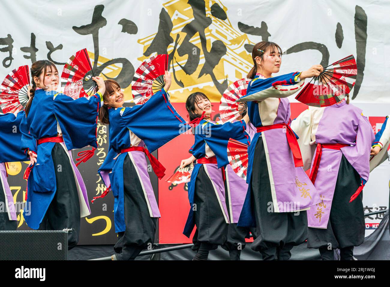 Japanische Teenager-Frauen Yosakoi tanzen in Yukata-Tuniken und halten Fans auf einer Open-Air-Bühne beim jährlichen Kyusyu Gassai Festival in Kumamoto Stockfoto