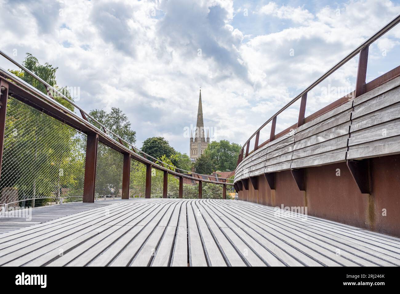 Lange Holzplanken auf der Jarrold Bridge führen in Richtung Norwich Cathedral, die im August 2023 über dem Wensum abgebildet wurde. Stockfoto