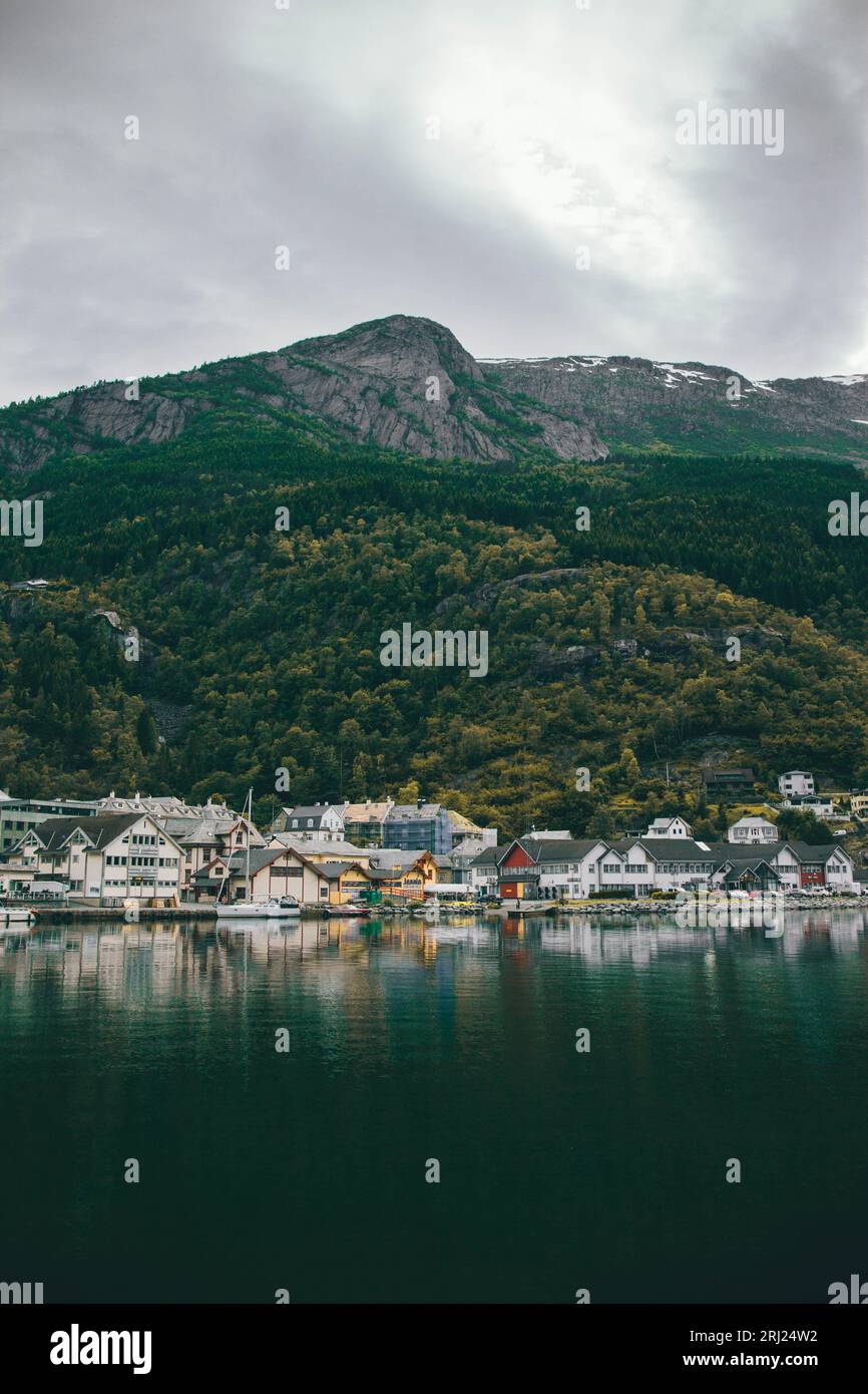 Kleine Stadt an einem Fjord in Norwegen mit Bergen im Hintergrund Stockfoto