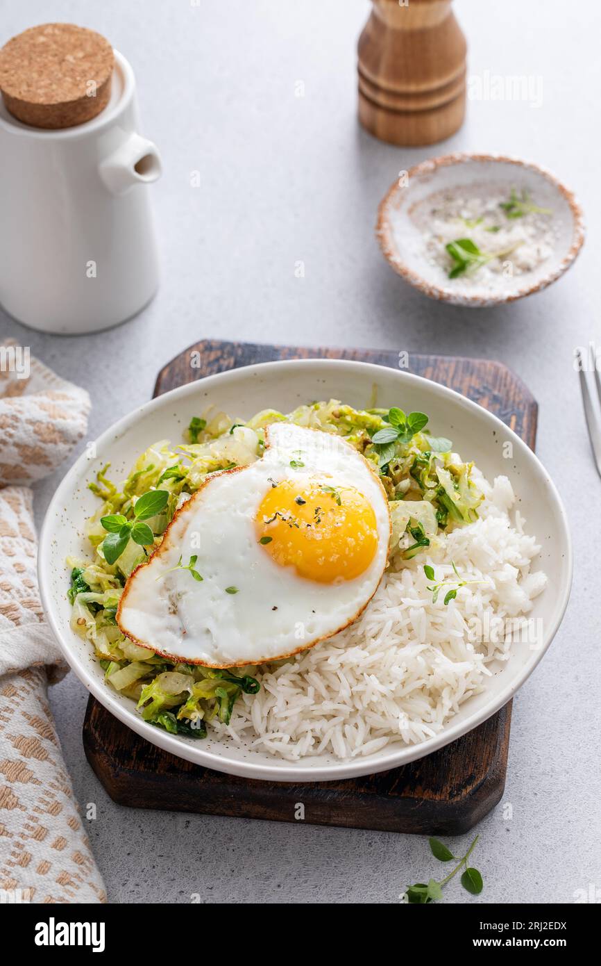 Reisschale mit sautiertem Kohl und Spiegelei, gesundes Mittag- oder Frühstück Stockfoto