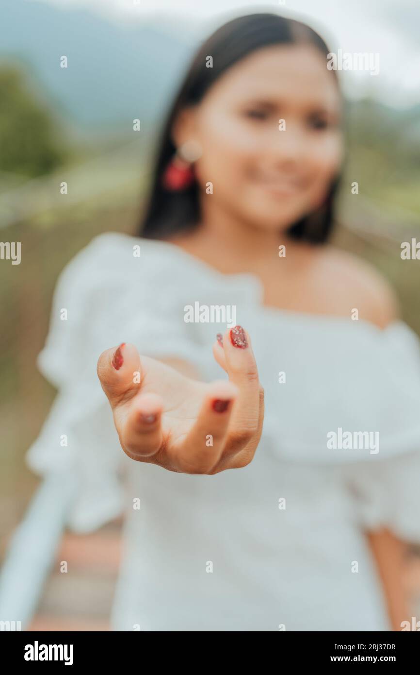Eine attraktive Frau steht in einer malerischen Umgebung im Freien und trägt ein weißes Kleid Stockfoto