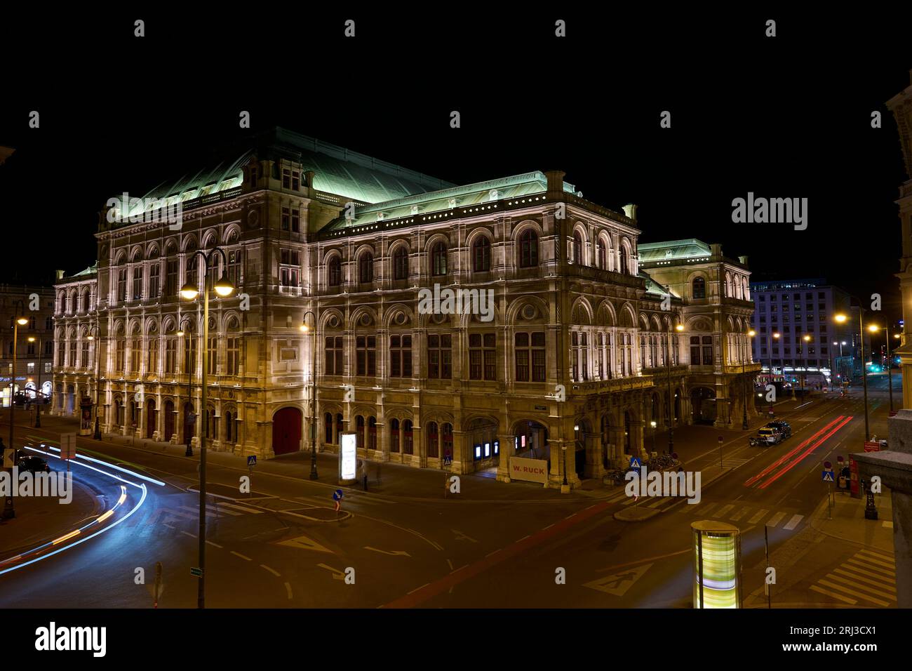 Ein Blick aus der Vogelperspektive auf eine Kreuzung vor der Wiener Staatsoper mit zahlreichen beleuchteten Straßenlaternen Stockfoto