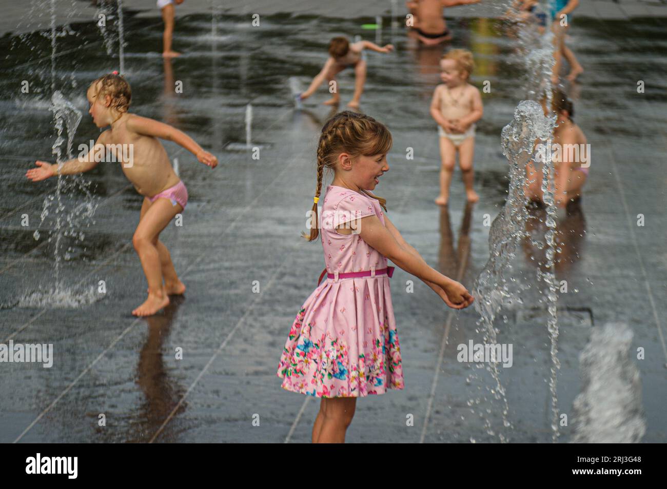 Vilnius, Litauen. August 2023. Kinder kühlen sich in einem öffentlichen Brunnen in Vilnius ab. Das heiße Wetter in Litauen hält an, da die Temperaturen auf 32 Grad steigen. Quelle: SOPA Images Limited/Alamy Live News Stockfoto