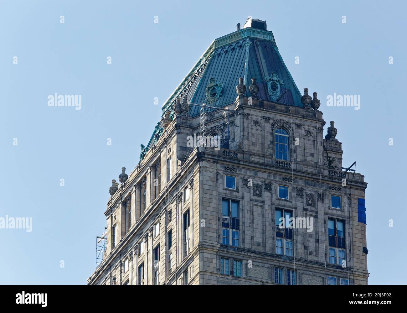 Die Kupferkappe des Pierre Hotels, das Wahrzeichen von New York City, ist von runden Fenstern durchbrochen und von monumentalen Urnen umgeben, hoch über der Fifth Avenue an der 61st Street. Stockfoto