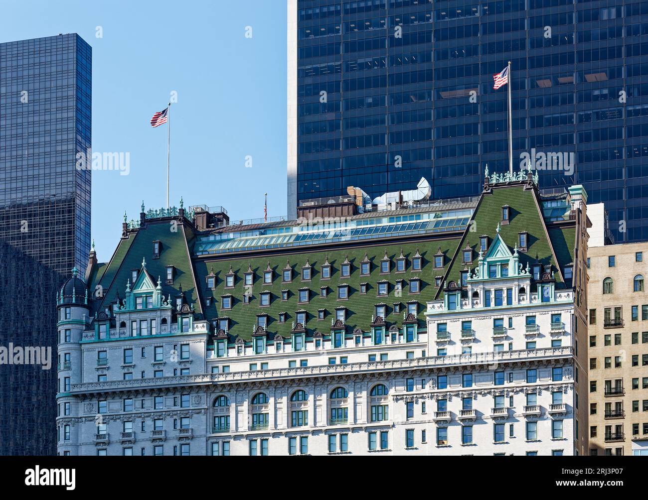 Das Plaza, ein Wahrzeichen von New York City, wurde von Henry J. Hardenbergh im Stil des französischen Renaissance Revival entworfen. Das Solow-Gebäude mit Glasfassade bildet die Kulisse. Stockfoto