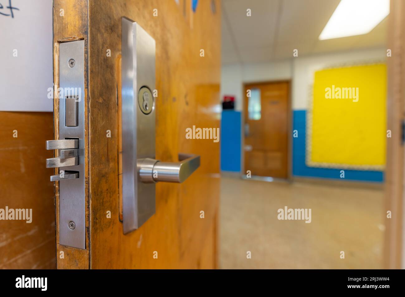 Öffnen Sie die Klassentür mit neuen Türbeschlägen mit Sicherheitsschlössern für eine Verriegelung. Stockfoto