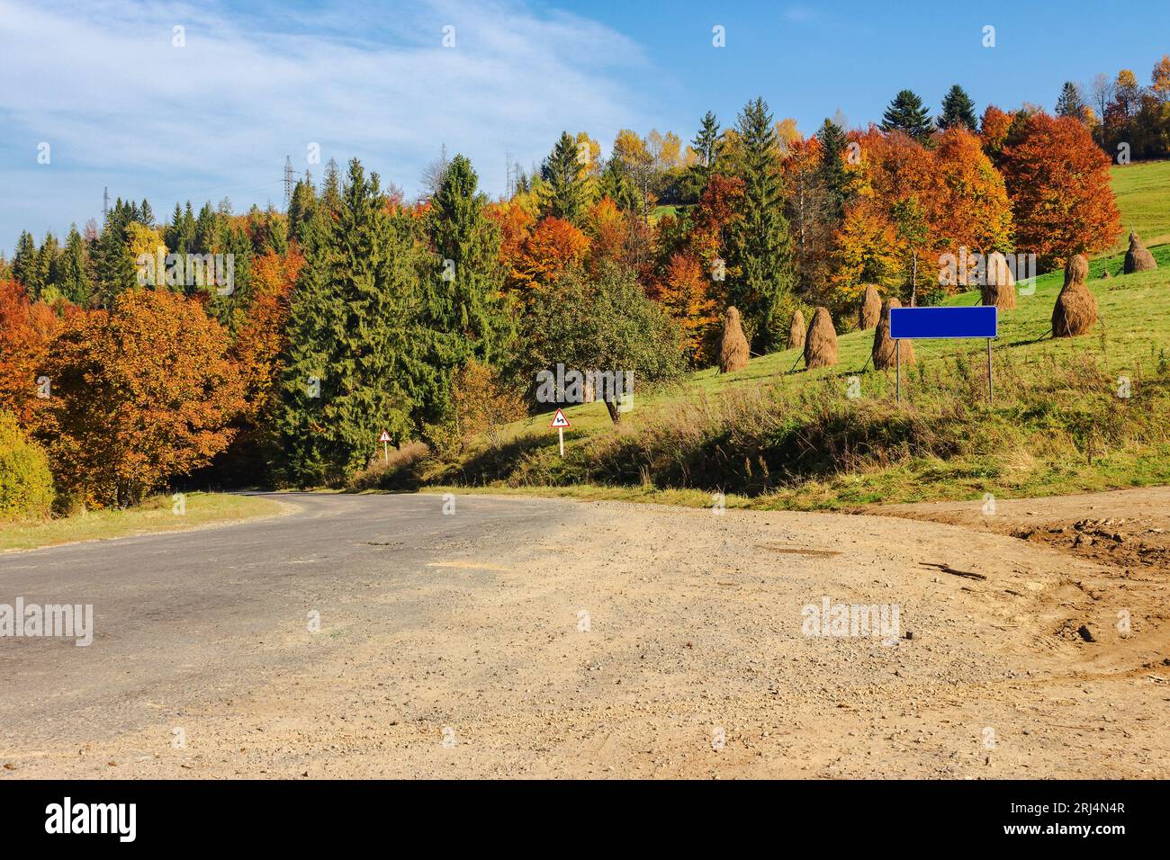Asphaltstraße in den Bergen. Ausflug durch die Landschaft im Herbst. Mischwald im Herbstlaub an einem sonnigen Tag Stockfoto