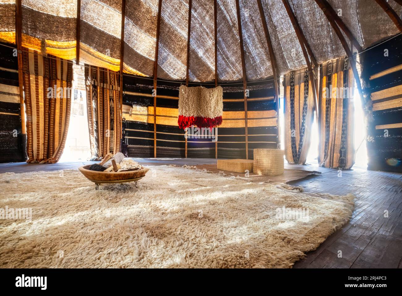 Ein fesselndes Foto hebt ein traditionelles Qatari-Zelt hervor, das als „Beduinen“-Zelt bekannt ist. Seine einzigartige Struktur, die von Holzstangen gestützt und mit innen verziert ist Stockfoto