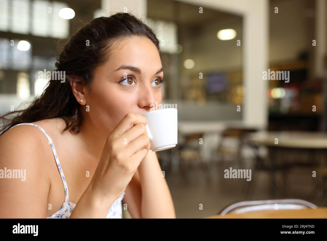 Frau, die Kaffee trinkt, sitzt in einer Bar Stockfoto