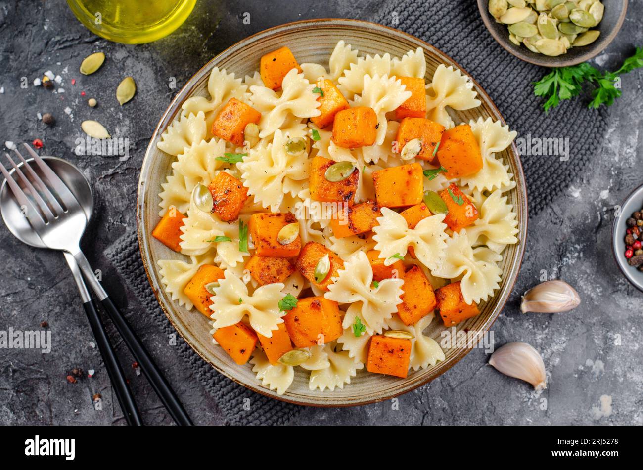 Pasta mit geröstetem Kürbis, Farfalle Pasta mit Kürbis auf einem Teller auf dunklem rustikalem Hintergrund Stockfoto
