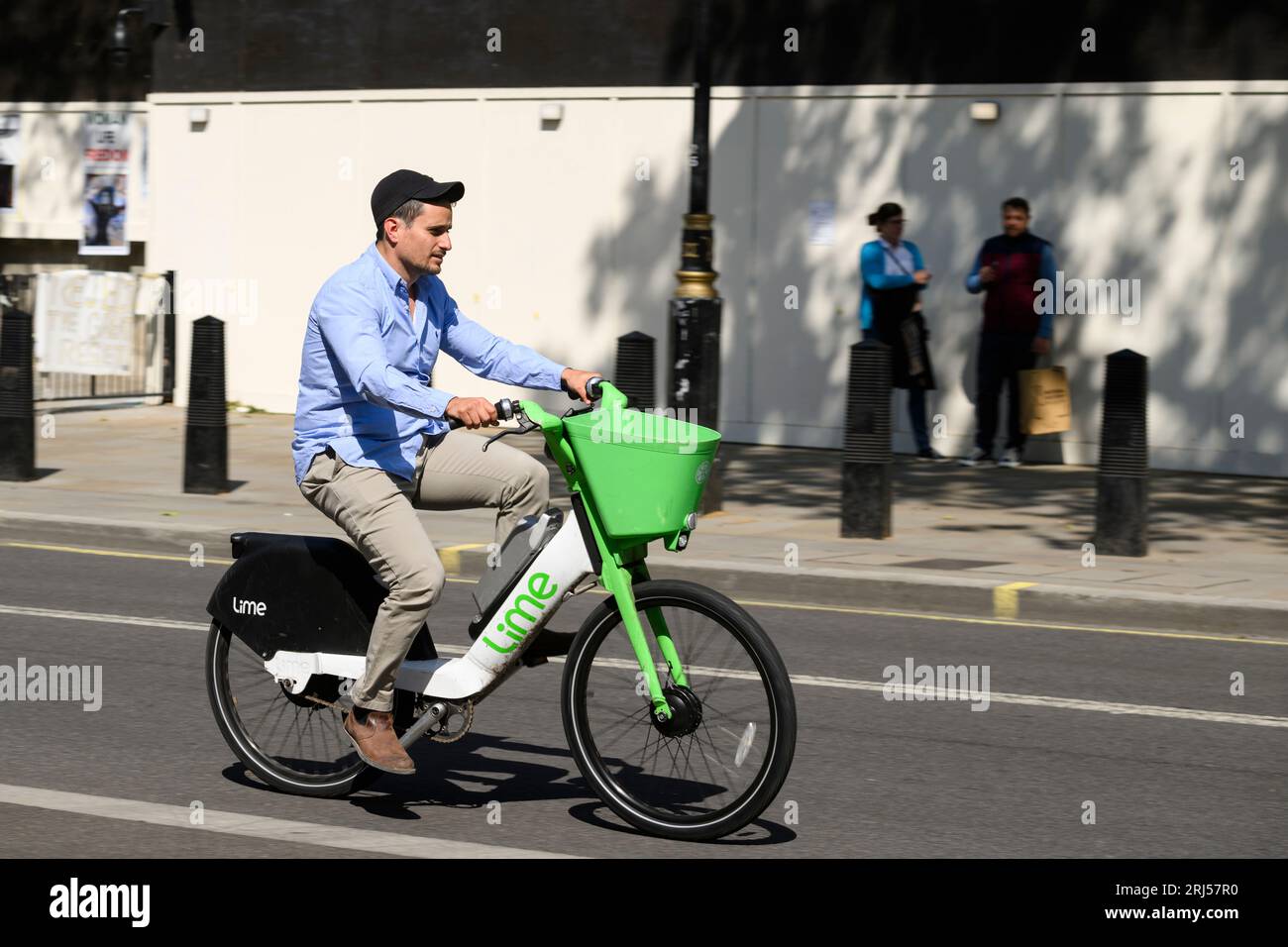 Ein Mann, der mit einem Lime-Elektrofahrrad in Whitehall, London, Großbritannien fährt. 7. Juni 2023 Stockfoto