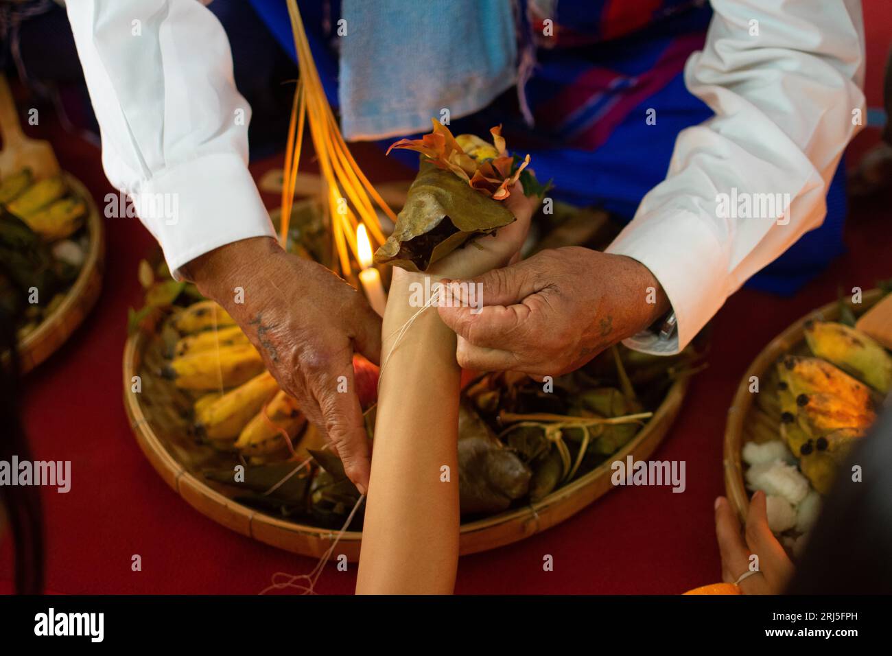 Karen traditionelle Handgelenkbindezeremonie: Binden von weißen und roten Baumwollfäden am Handgelenk. Eine der berühmtesten Veranstaltungen. Stockfoto