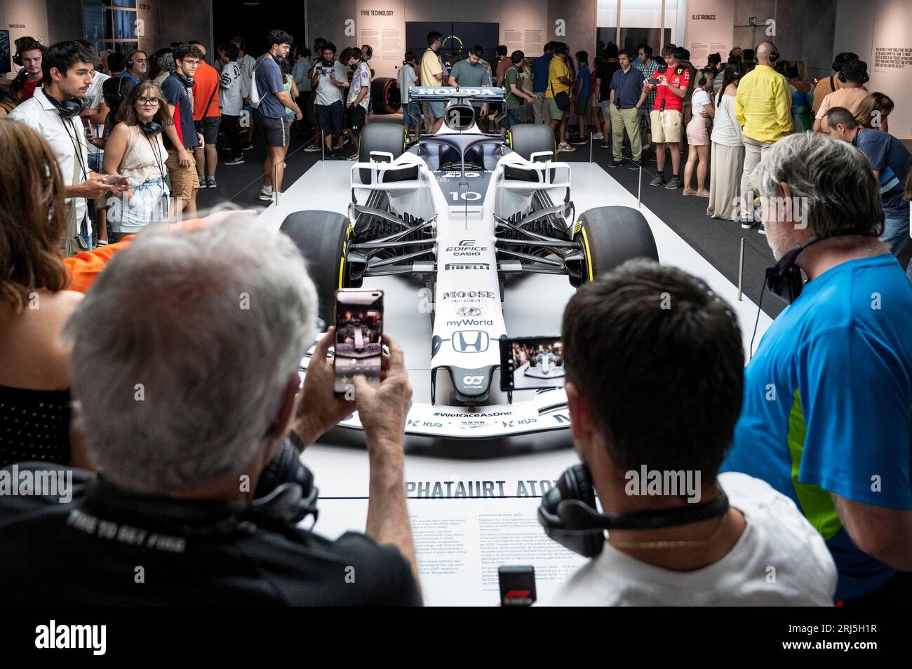 Madrid, Spanien. August 2023. Die Leute schauen und machen Fotos vom F1-Autorennen Lotus 49, Alpha Tauri, der von dem französischen Rennfahrer Pierre Gasly während der weltweit ersten offiziellen Formel-1-Ausstellung (FIA) auf der IFEMA Madrid gefahren wird. Das immersive Event zeigt die Vergangenheit, Gegenwart und Zukunft dieses Sports. Quelle: SOPA Images Limited/Alamy Live News Stockfoto