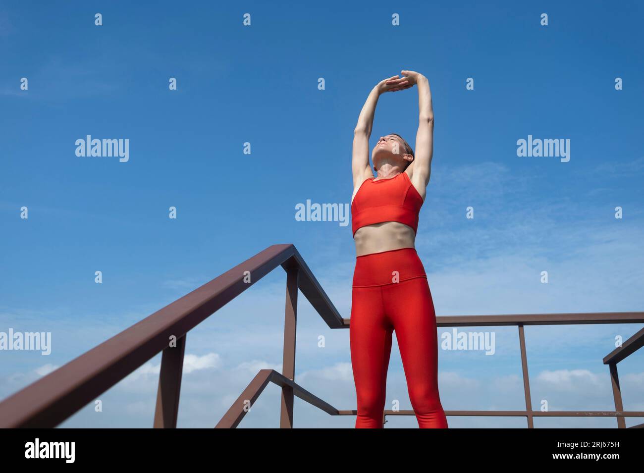 FIT, sportliche Frau, die draußen einen Arm dehnt, Outdoor-Fitnesskonzept. Stockfoto