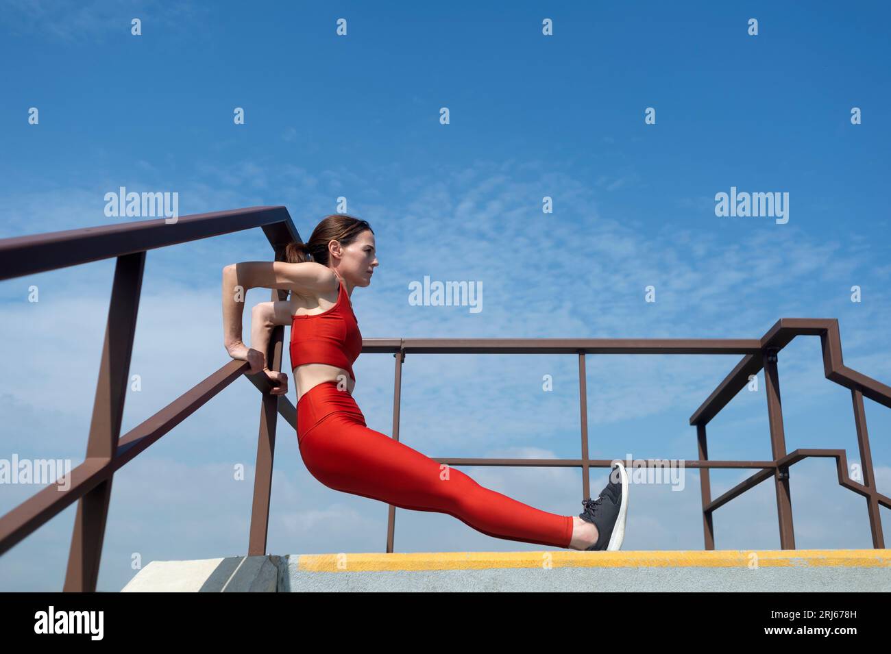 Seitenansicht der Frau in voller Länge, die sich rückwärts hochlegt. Outdoor-Fitnesskonzept. Stockfoto