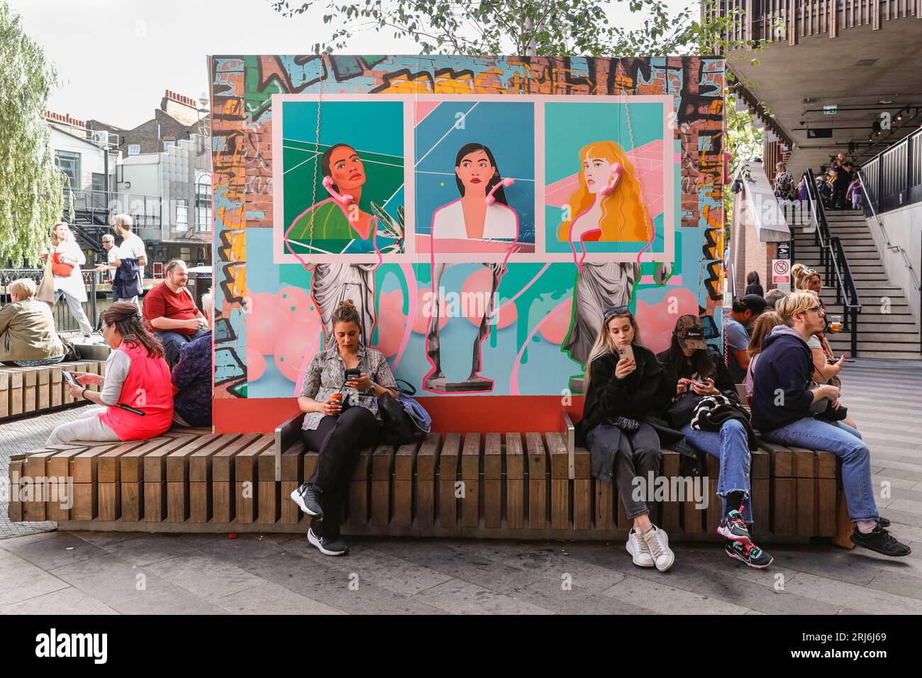 Camden Market Hawley Wharf und Leute, die auf Mobiltelefonen sitzen, Camden Town, London, England Stockfoto