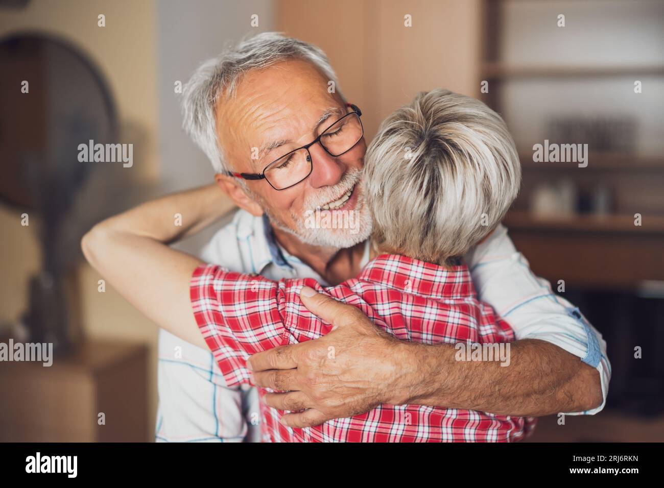 Porträt eines glücklichen älteren Ehepaars zu Hause. Seniorenumarmung. Stockfoto