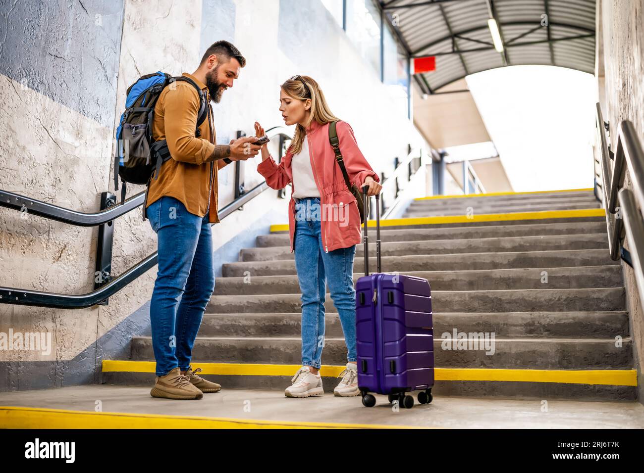 Ein erwachsenes Paar hat die Abfahrt des Zuges verpasst. Die streiten am Bahnhof. Stockfoto