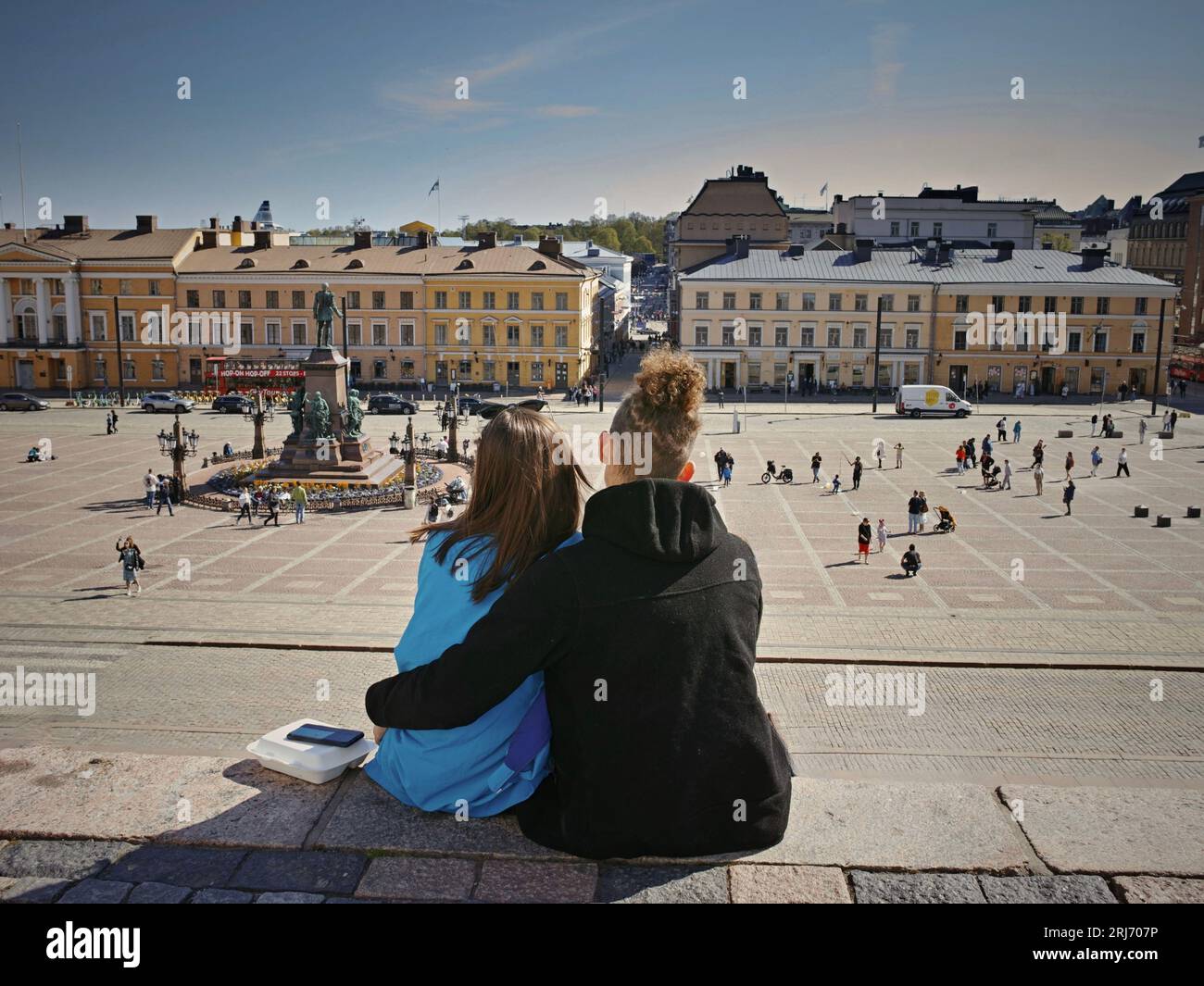Zwei junge Erwachsene sitzen auf den Stufen eines Wohnhauses in Helsinki Stockfoto