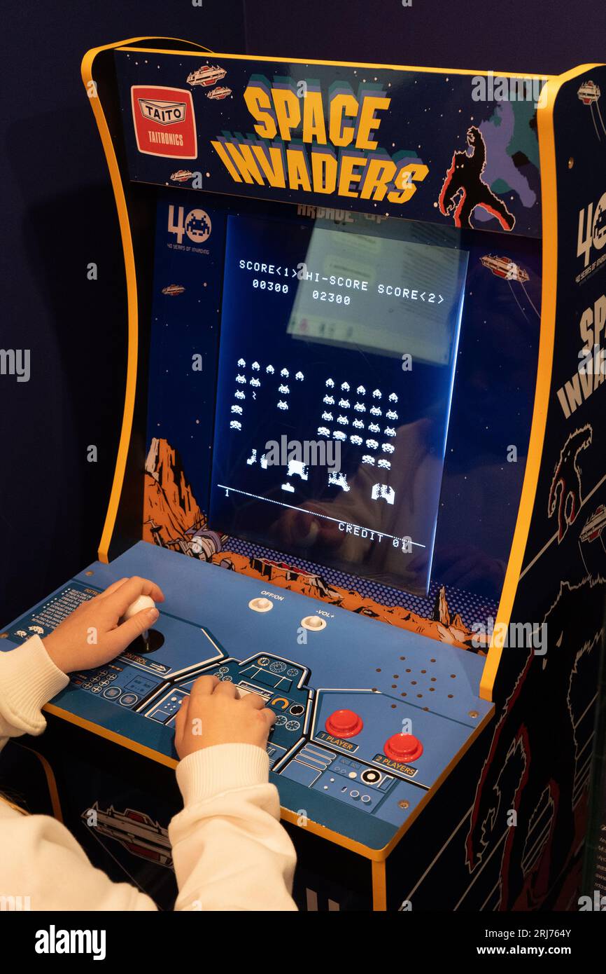 Raumeindringlinge Taito Spielmaschine. Simple Space Arcade in einem alten 8-Bit-Retro-Video. Kinder spielen klassische Spielautomaten. Warschau, Polen - 28. Juli 2023. Stockfoto