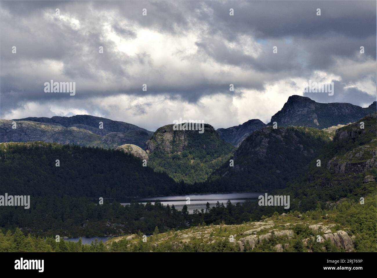Tauchen Sie ein in Stavanger's ruhige Wanderung: Ein ruhiger Bergsee umgeben von Bäumen und monumentalen Steingipfeln. Die Pracht der Natur in Norwegen. #MountainHike Stockfoto