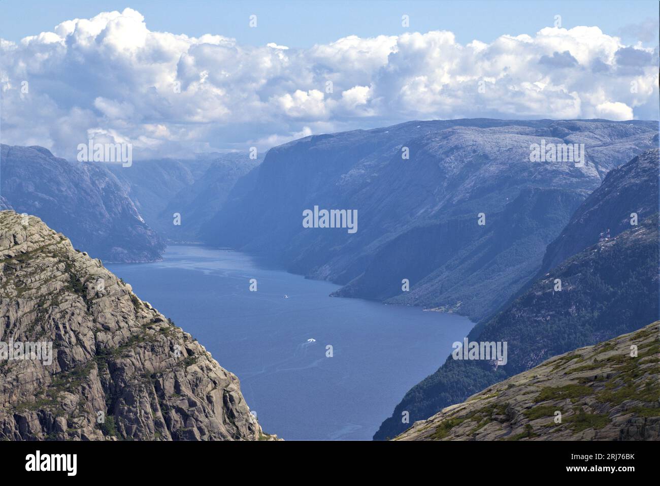 Begeben Sie sich auf ein unvergessliches norwegisches Abenteuer in der Nähe von Stavanger, wo hoch aufragende Berge auf dieser fesselnden Wanderung über einen gewundenen Fjord wachen. Stockfoto