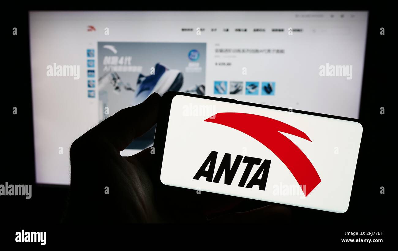 Person, die ein Smartphone mit dem Logo des chinesischen Unternehmens Anta Sports Products Limited auf dem Bildschirm vor der Website hält. Konzentrieren Sie sich auf das Display des Telefons. Stockfoto