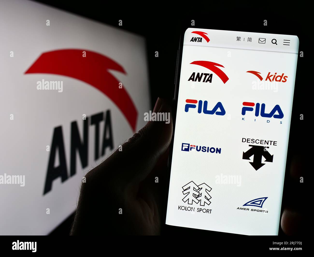 Person, die ein Mobiltelefon mit der Website des chinesischen Unternehmens Anta Sports Products Limited auf dem Bildschirm mit Logo hält. Konzentrieren Sie sich auf die Mitte der Telefonanzeige. Stockfoto