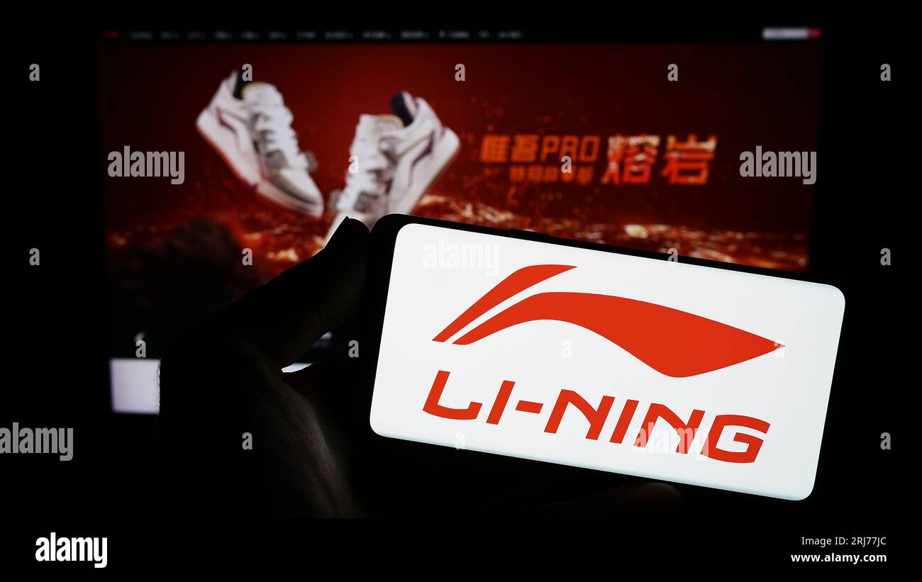 Person, die ein Smartphone mit dem Logo des chinesischen Unternehmens Li-Ning Company Limited auf dem Bildschirm vor der Website hält. Konzentrieren Sie sich auf das Display des Telefons. Stockfoto