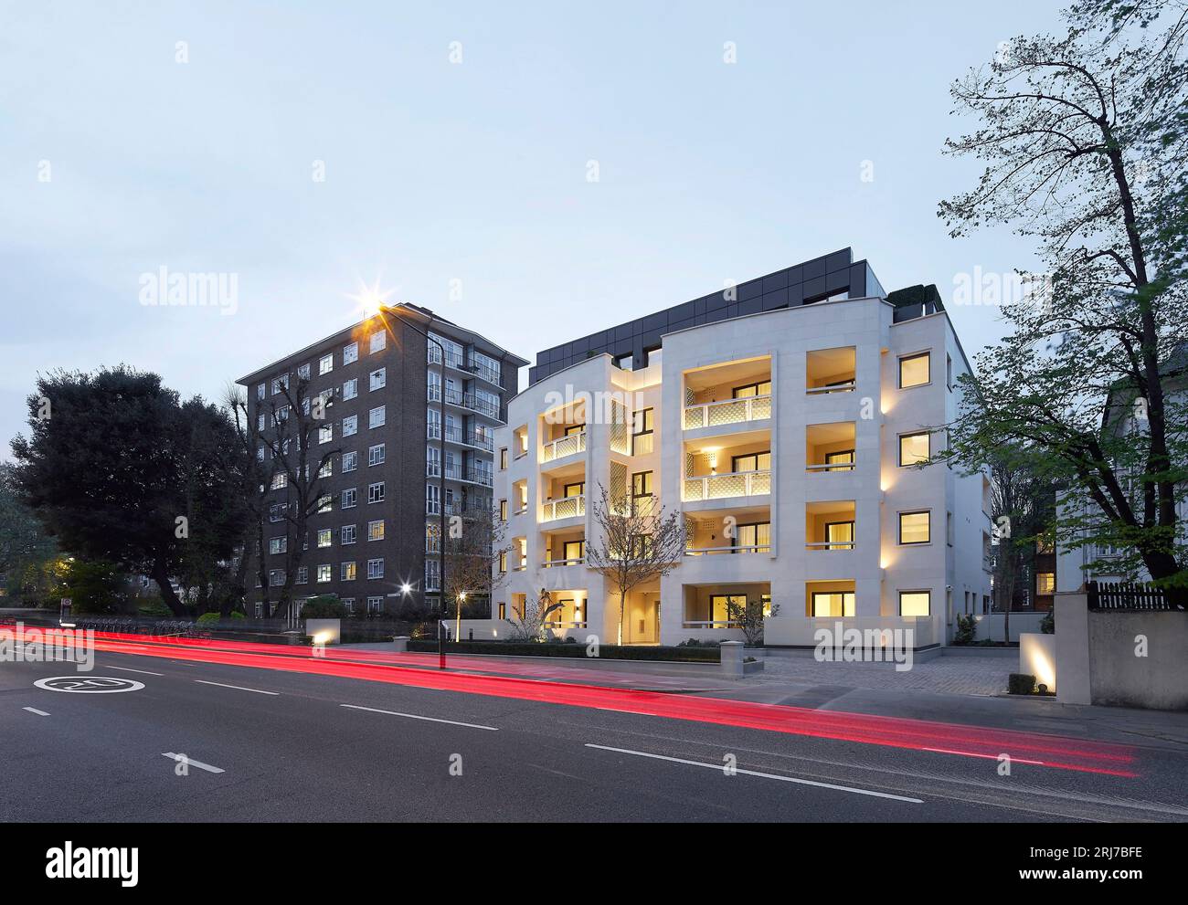 Gebäude mit beleuchtetem Interieur in der Abenddämmerung. Wellington Road, London, Vereinigtes Königreich. Architekt: Alan Power Architects Ltd, 2022. Stockfoto
