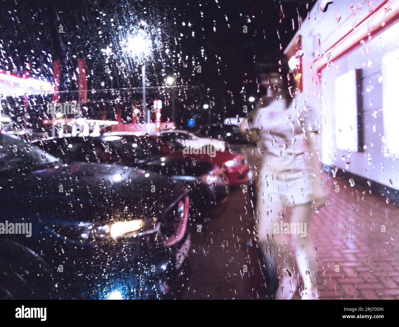 Parkplatz an der Tankstelle in der Regennacht Stockfoto