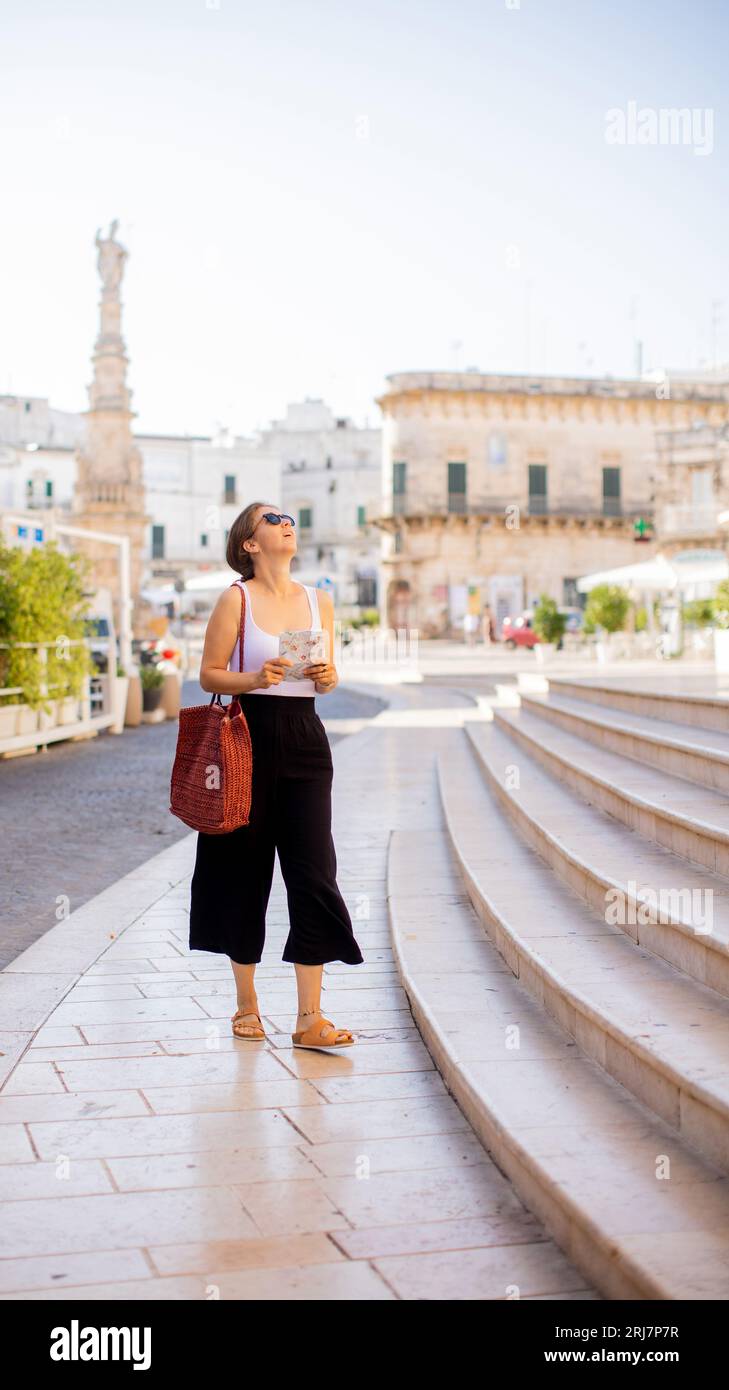 Weibliche Touristen mit einem Stadtplan von der Statue des Heiligen Oronzo in Ostuni, Italien Stockfoto