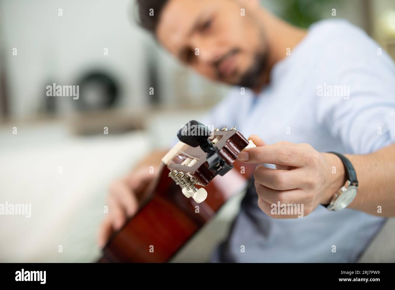 Junge gut aussehende Werkstatt Reparatur Gitarre Stockfoto