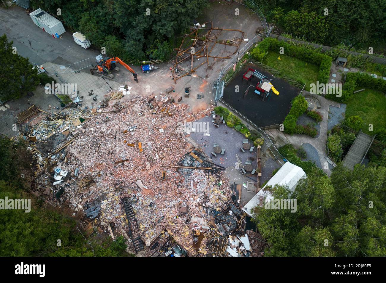 Himley Road, Himley, 21. August 2023: Neue Abrissmannschaften befinden sich auf dem Gelände der Crooked Hoiuse, die in Großbritannien als Wonkiest Pub bezeichnet wird. Arbeiter und 2 Bagger behaupten, dass sie Ziegel entfernen, die für den Wiederaufbau der Kneipe verwendet werden könnten, die Anfang August niederbrannte und 48 Stunden später abgerissen wurde. Quelle: Stop Press Media/Alamy Live News Stockfoto